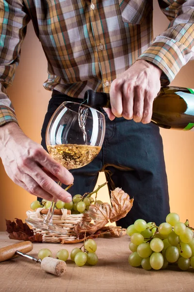 Bottle of white wine and grapes on a wooden table — Stock Photo, Image