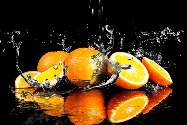 Frutas de laranja e água salpicante — Fotografia de Stock