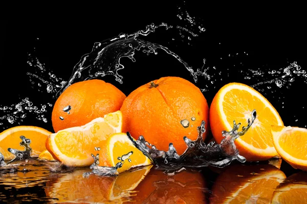 Oranje vruchten en spatten water — Stockfoto