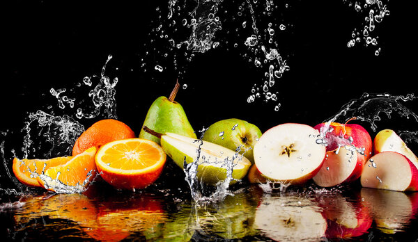 Груши, яблоки, апельсиновые фрукты и брызги воды
