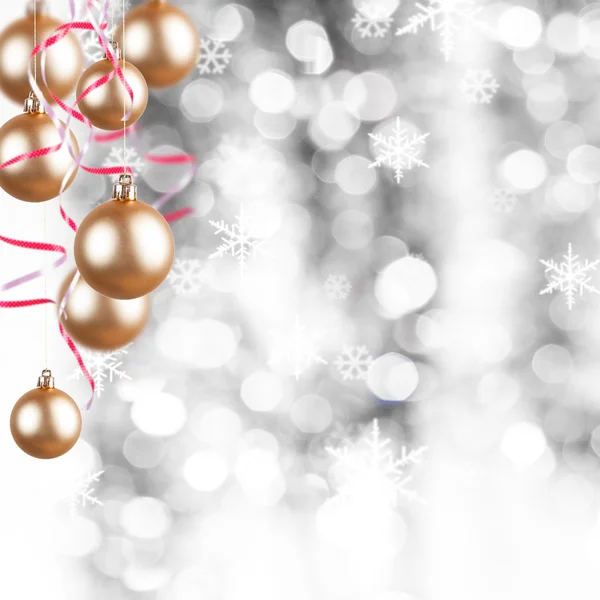 Golden Christmas ornaments on a silver background with flakes — Stock Photo, Image