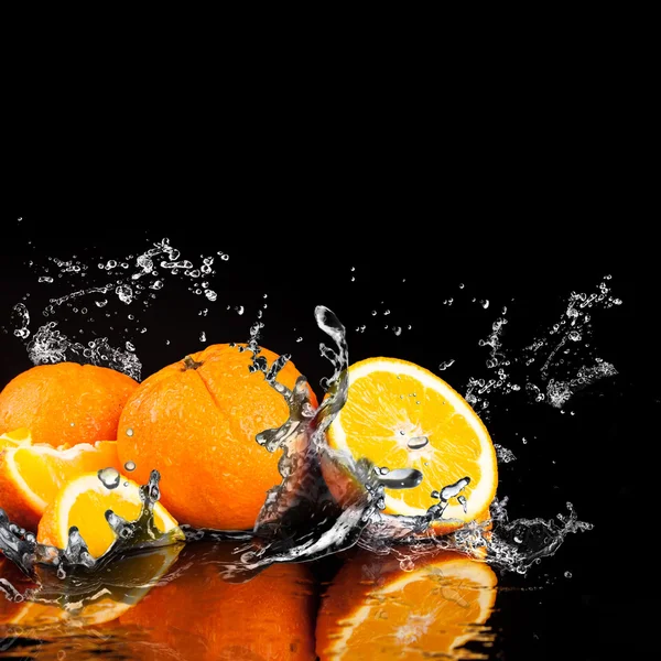 Oranje vruchten en spatten water — Stockfoto