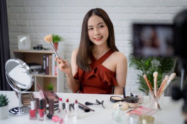 Profesyonel bir Asyalı güzellik blogcusu sosyal medyada paylaşmak için makyaj ve kayıt videoları öğretiyor.