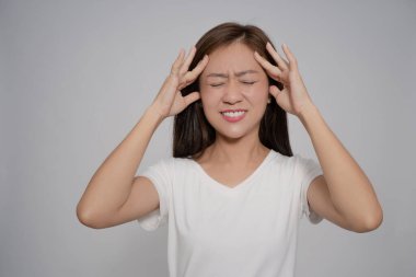 Beyaz arka planda Asyalı kadın baş ağrısı. Elleriyle kafasına dokundu..
