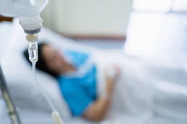 Arkaplanda hasta kadına verilen serum serumuna odaklan..