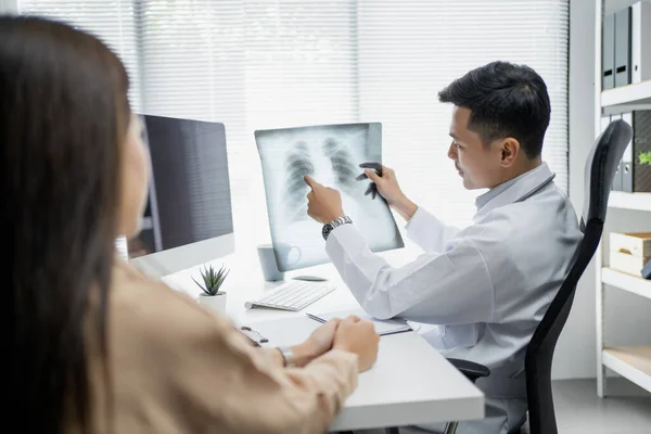 아시아 의사가 환자에게 엑스레이 필름을 설명하고 있어요 관심과 건강에 — 스톡 사진