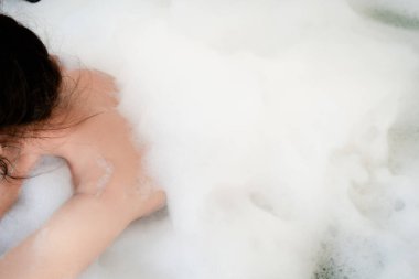 Kadın banyoda vücudunu temizlemek için sabun kullanıyor. Cilt bakımı konsepti.