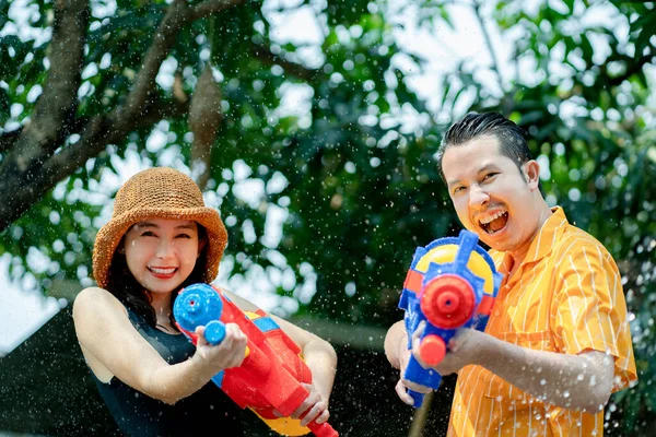 Asian people enjoy water guns playing in the Thai Songkran Festival in the summer of April.