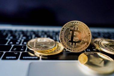 Sanal kripto para birimi kavramı. Dizüstü bilgisayardaki altın paralar yakın plan..