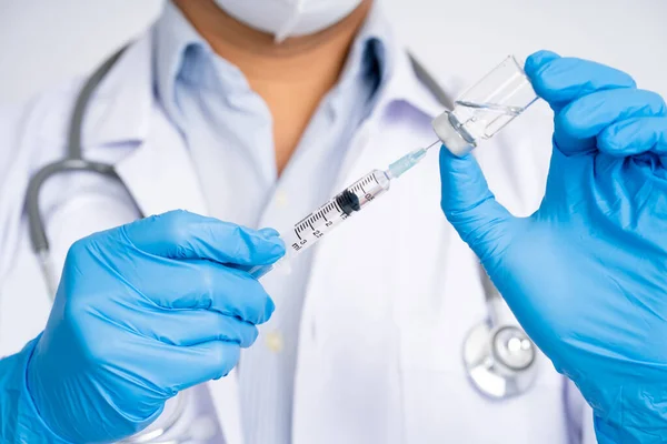 青い手袋を着用した医師は Covid 19ワクチンまたはコロナウイルス予防接種インフルエンザ治療ワクチン接種を保持 — ストック写真