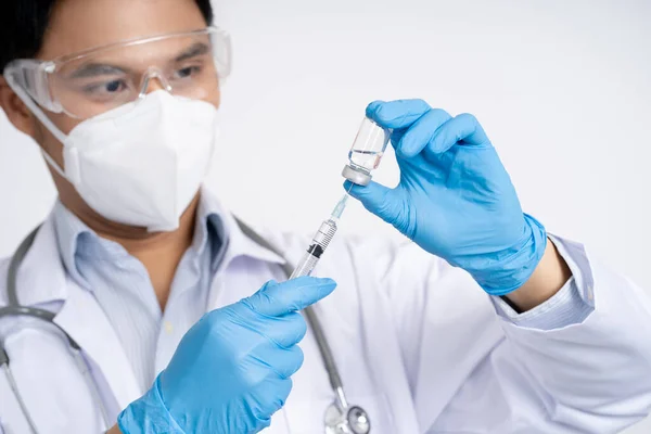 健康和医疗概念 亚洲医生拿着一瓶Covid 19疫苗和注射器的特写照片 为人类临床试验做准备 — 图库照片