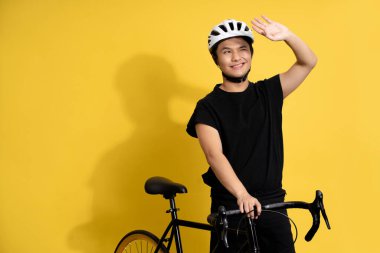 Yakışıklı Asyalı adam. Güneşte bisiklet sürüyor..