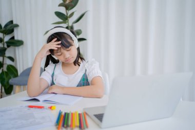 Asyalı kız evde online çalışma konusunda sıkılmış ve stresli. Çevrimiçi eğitim, ev okulu kavramı.