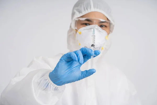 注射器と針を持っている医者 彼女は白い背景に保護研究室のスーツ マスク アイウェアゴーグルを身に着けている Covid 19ワクチンイラスト — ストック写真