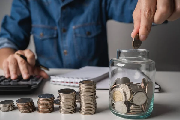 Businessman Hand Holding Coins Putting Jar Recording Income Expenses Account — Stock Photo, Image