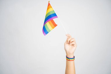 LGBT konsepti. Beyaz arka planda gökkuşağı bayrağı tutuyor. İzole edilmiş arkaplan.