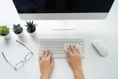 Klavyesi ve bilgisayarı olan masaüstü görüntüsü. İnsan eli dezenfeksiyon için klavyeyi antiseptik bezle siler..