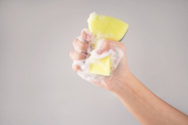 Bulaşık yıkamak için sarı sünger. Ev işleri ve malzeme konsepti. İzole edilmiş arkaplan.