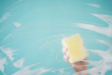 Eller pencereleri sünger ve deterjanla temizliyor..