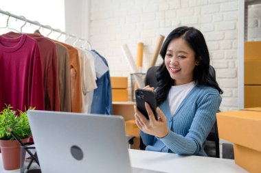 KOBİ Başlangıcı. Küçük işletme girişimcisi. Başarılı Asyalı Kadın İşletme Sahibi Ürünleri Satıyor, Müşterilerden Siparişler Alıyor