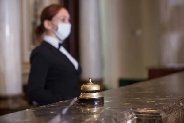 the hotel staff serves guests in medical masks