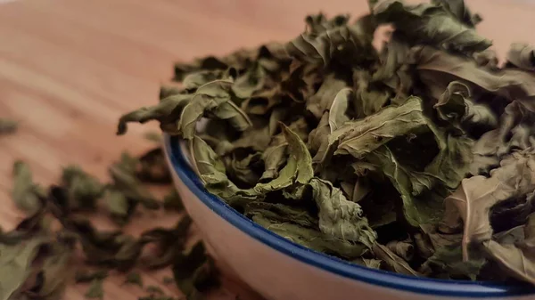These dried mint leaves are ready to be used in tea or meal preparation. This image is a close up of the actual mint leaves. The use of mint is great for getting a nice breath and it also tastes amazing in any type of herbal tea.