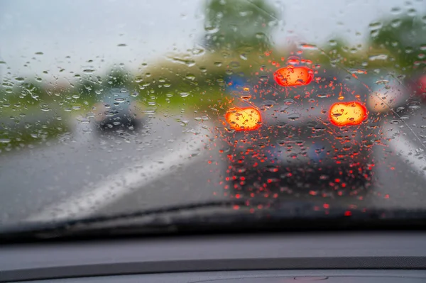 Car driving in the rain with drops on windshield