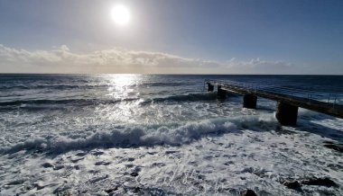 Madeira Adası 'ndaki küçük bir sahil kasabasında, adaların volkanik kökeninin göstergesi olarak kıyı şeridi boyunca siyah volkanik toprak bulunur. Kasaba iskelesi Atlantik 'e kadar uzanıyor, dalgaların kayalara ve kıyılara çarptığı ve dinamik bir hava yarattığı yere.