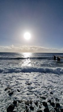 Madeira Adası 'ndaki küçük bir sahil kasabasında, adaların volkanik kökeninin göstergesi olarak kıyı şeridi boyunca siyah volkanik toprak bulunur. Kasaba iskelesi Atlantik 'e kadar uzanıyor, dalgaların kayalara ve kıyılara çarptığı ve dinamik bir hava yarattığı yere.