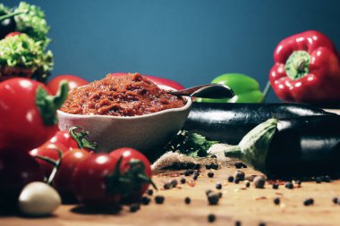 Patlıcan havyarı. Tahtadaki soğan, biber, domates ve baharatlar