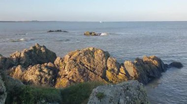 İrlanda kıyı şeridi, rüzgarın denizin seslerini taşıması ve teknelerin sürüklenip balık tutması ve sahilin sakin ama canlı atmosferinin tadını çıkarması gibi..