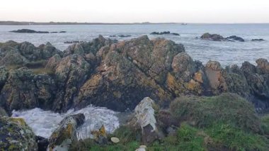 İrlanda kıyı şeridi, rüzgarın denizin seslerini taşıması ve teknelerin sürüklenip balık tutması ve sahilin sakin ama canlı atmosferinin tadını çıkarması gibi..