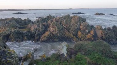 İrlanda kıyı şeridi, rüzgarın denizin seslerini taşıması ve teknelerin sürüklenip balık tutması ve sahilin sakin ama canlı atmosferinin tadını çıkarması gibi..