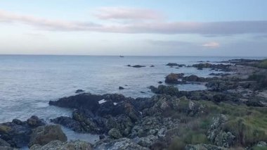 İrlanda kıyı şeridi, rüzgarın denizin seslerini taşıması ve teknelerin sürüklenip balık tutması ve sahilin sakin ama canlı atmosferinin tadını çıkarması gibi..