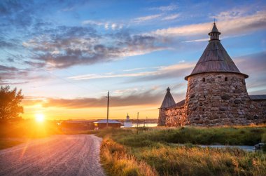 Solovetsky Manastırı 'nın taş kuleleri batan güneşin ve yolun ışığında