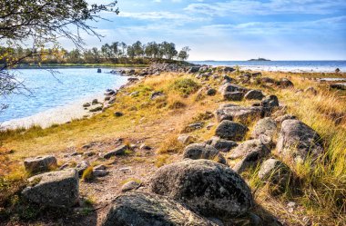 Solovetsky Adaları 'ndaki Filippovsky kafeslerindeki büyük kayalar Beyaz Deniz' in mavi suları arasında.