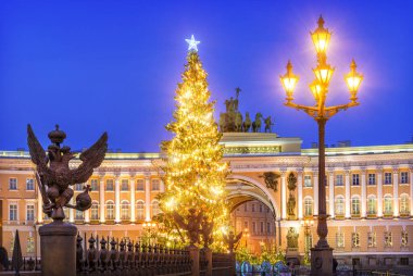 Palace Meydanı 'nda iki başlı kartal figürleri ve St. Petersburg' daki ana merkezin kemerinde gece ışığı altında yeni yıl ağacı.