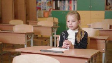 İlkokul çağındaki bir kız masada oturuyor ve sınava girme konusunda çok endişeli. Sınav sırasında gerginlik. Gerçek duygular.