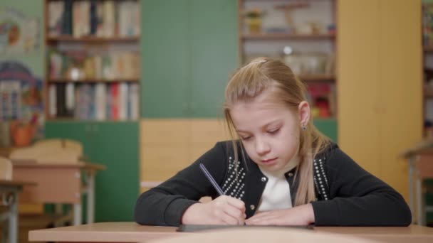 Una Niña Edad Escolar Sienta Escritorio Una Clase Escolar Ella — Vídeos de Stock