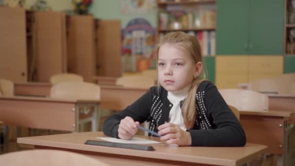 Egy Iskolás Lány Portréja Aki Egy Íróasztalnál Tollat Tart Kezében — Stock videók