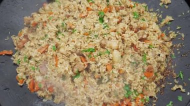 Büyük bir kazanda doğu pilavı pişirmek. Sıcak bir yemeğin yakın çekimi. Lezzetli doğu yemekleri..