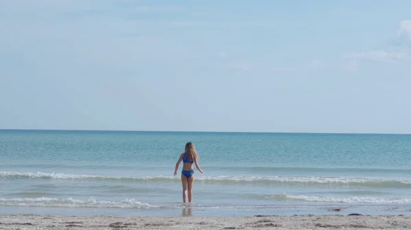 若い女の子は夏の晴れた日に海で泳ぎに行く 海辺での気楽な休暇 — ストック写真