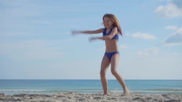 Kumlu Deniz Kıyısında Mayo Giymiş Neşeli Kaygısız Bir Kız Dans — Stok video