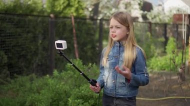 Genç bir kızın kendi video blogu var. Selfie çubuğuyla video kaydediyor. Aksiyon kamerasıyla yayınlanıyor..