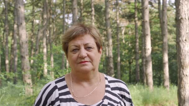 Una Mujer Mayor Está Mirando Cámara Contexto Bosque Coníferas Edad — Vídeo de stock
