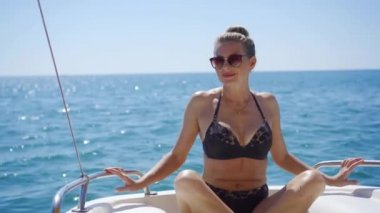 Güzel, başarılı orta yaşlı bir kadın yaz tatilinde. Güneşlenir, dalgaların üzerinde sallanan bir yatın güvertesinde oturur..