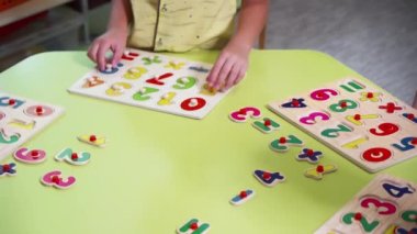 Üzerinde matematik ödevleri olan sayılar olan bir yazı masası. Sınıfta sorunları çözüyordum. Doğru kararı vermek. Karar verirken çocukların elleri..