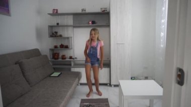 Kız evde yalnız dans ediyor. Karantina sırasında eğlence. Müziğe alışın..