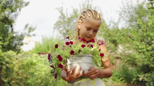 Saçları Örgülü Elinde Çiçek Tutan Bir Kız Bitkilerle Ilgilenmek — Stok video