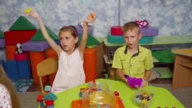 Anaokulu çocukları masaya oturur ve eğitici masa oyunları oynarlar. Oyun sırasında çocukların gerçek davranışları ve duyguları..